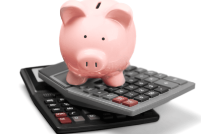 Cofrinho em formato de porco sobre calculadoras, representando economia e controle de banco de horas.